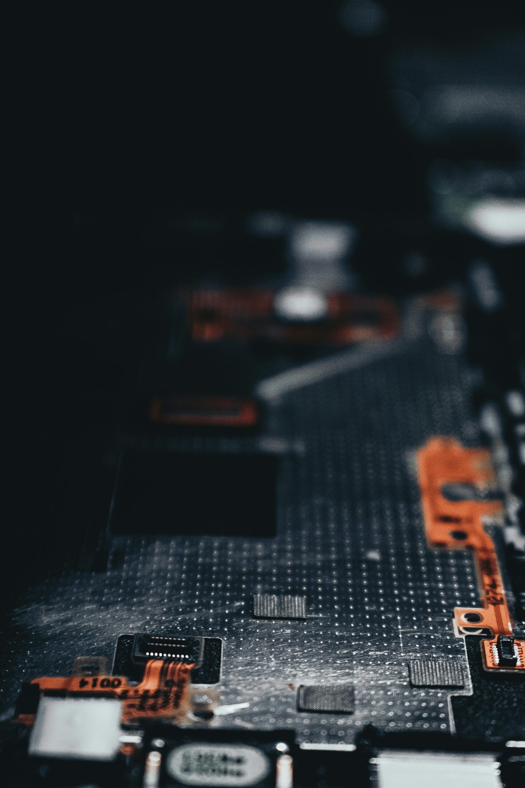Close-up of a dark circuit board showcasing electronic components and connections.