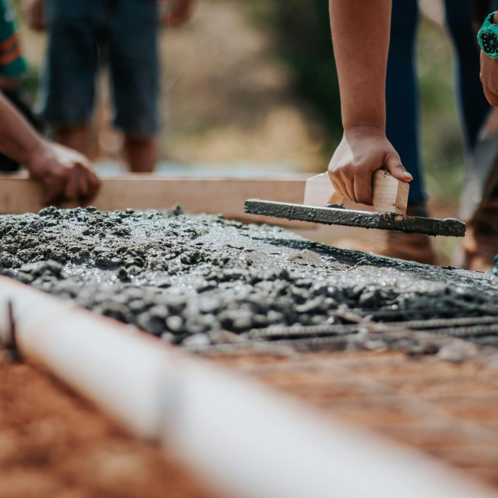 pexels photo 2219024 2219024 Construction workers leveling fresh cement on a sunny day at an outdoor site.