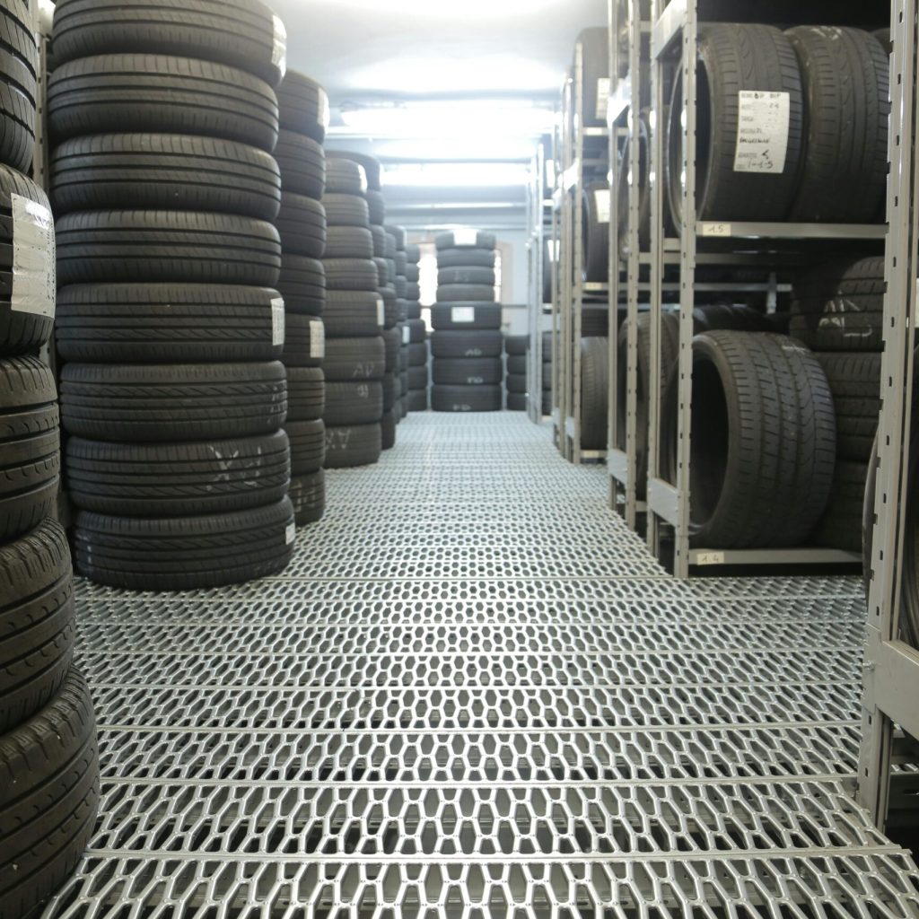 pexels photo 3806252 3806252 Rows of stacked tires in an indoor industrial warehouse for storage.
